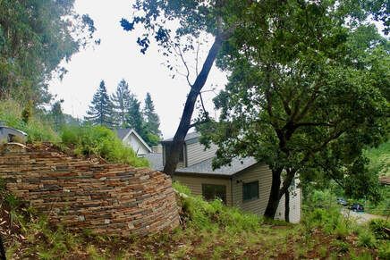 A house is sitting on top of a hill surrounded by trees.