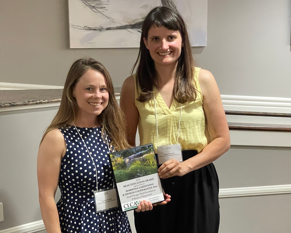 Two women are standing next to each other holding a certificate.