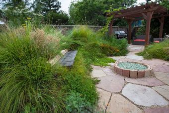 A stone walkway surrounded by purple flowers in a garden.