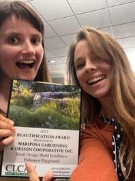 Two women are posing for a picture while holding a book.