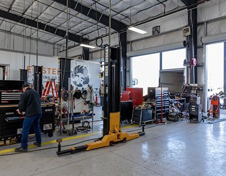 Yellow Hyundai forklift, propane tank, driver, RV, parked vehicles.
