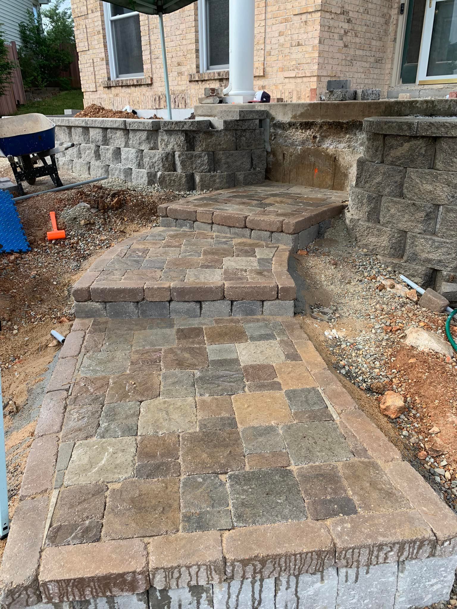 Brick pathway and steps leading up to a house entrance. Brickwork is multi-toned browns and tans.
