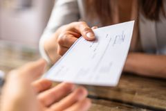 A woman is handing a check to another woman.