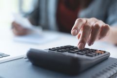 A person is using a calculator at a desk.