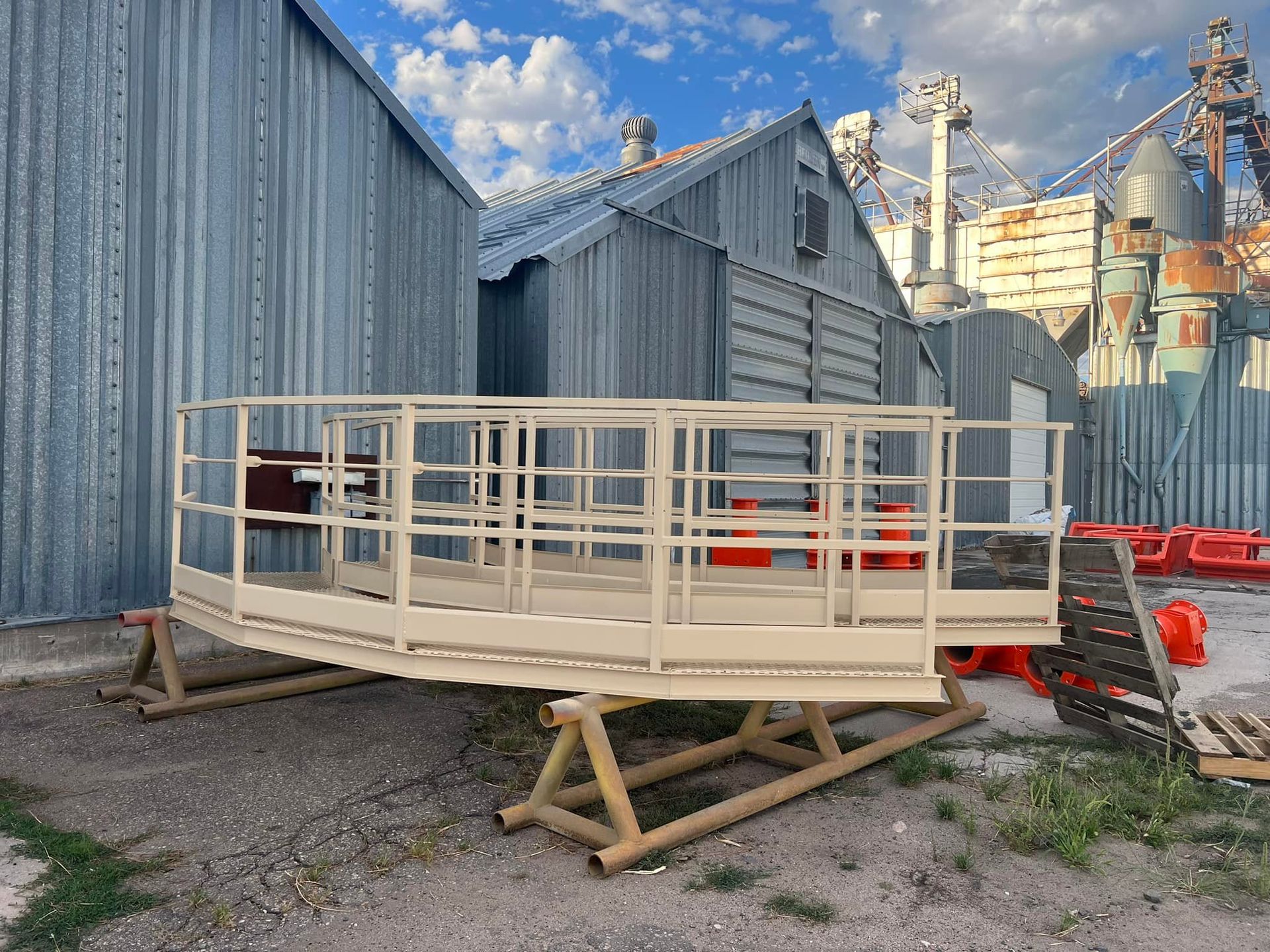 A metal platform with a railing is sitting in front of a building.