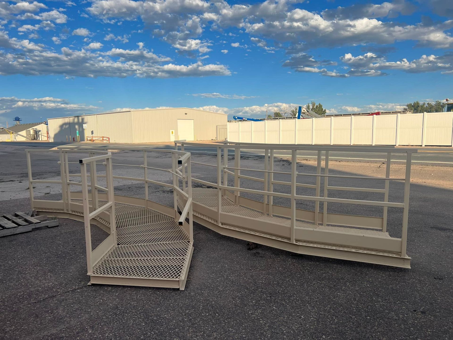 A bunch of metal crates are sitting on the ground in a parking lot.