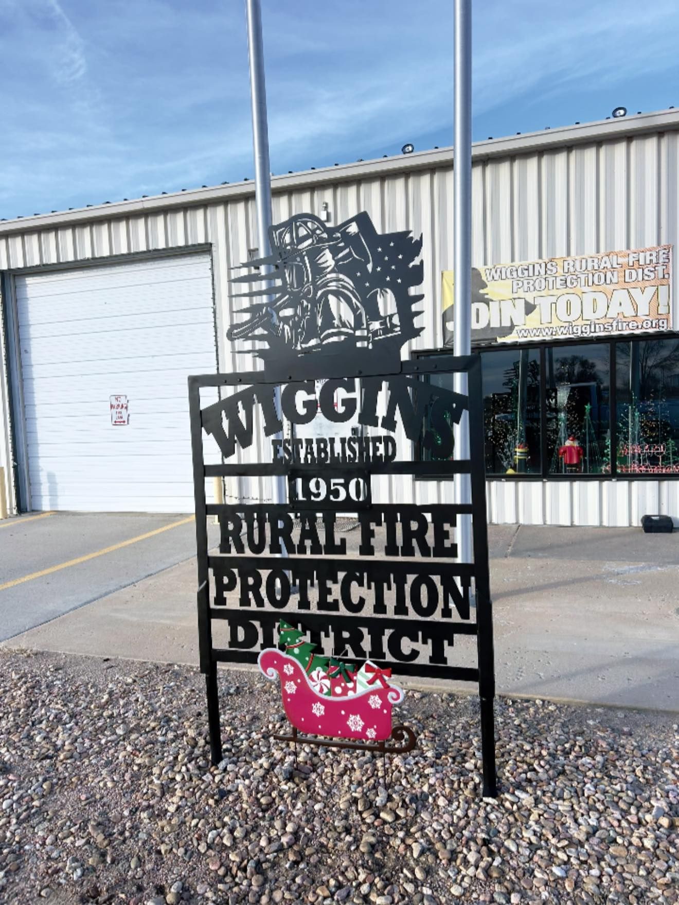A sign for the wisconsin rural fire protection district is in front of a building.