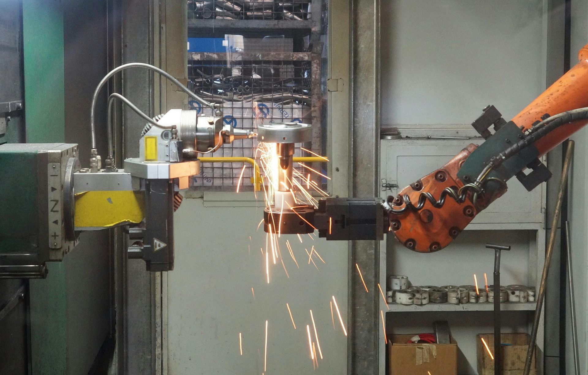 A robotic arm is cutting a piece of metal in a factory