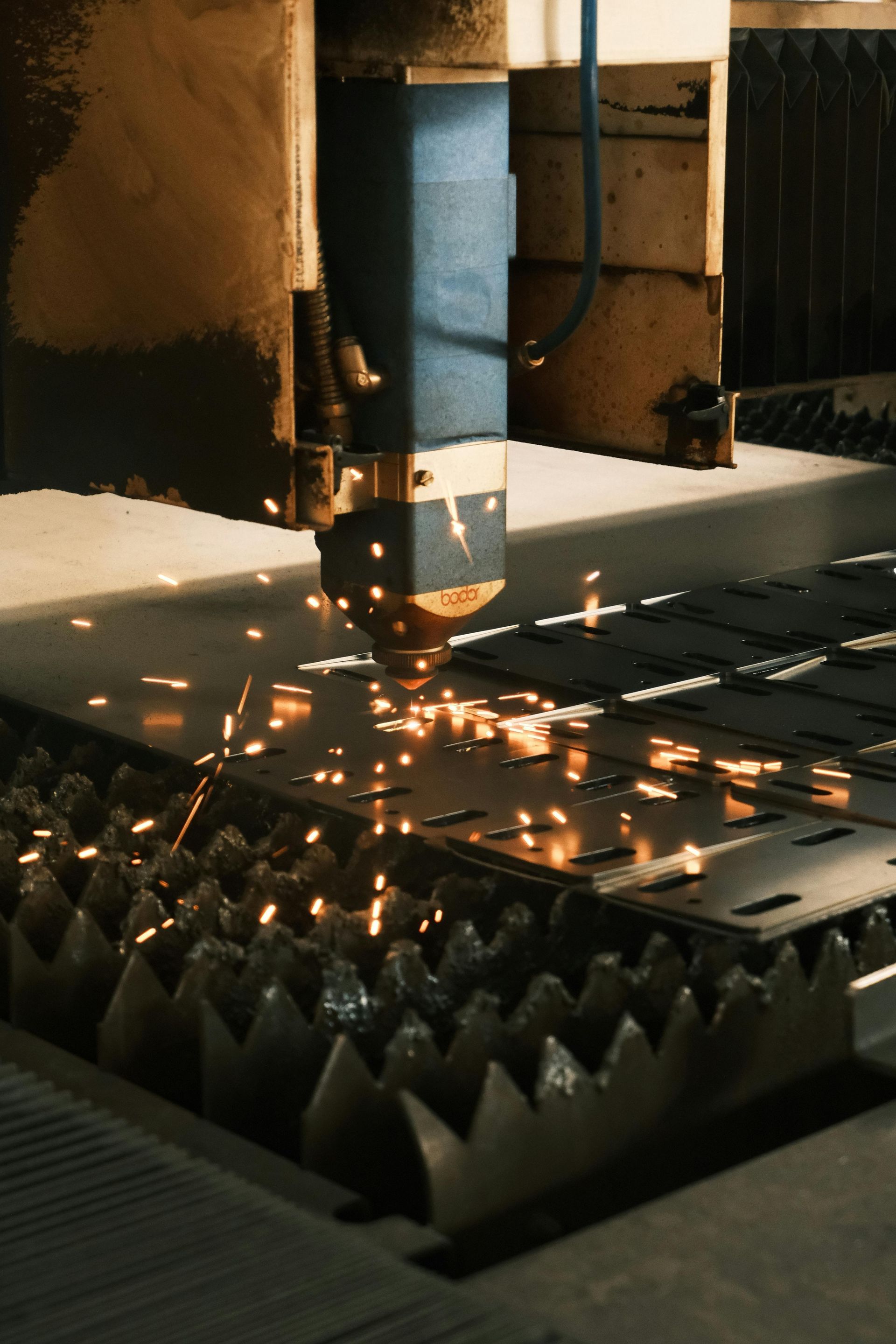 A machine is cutting a piece of metal with sparks coming out of it.