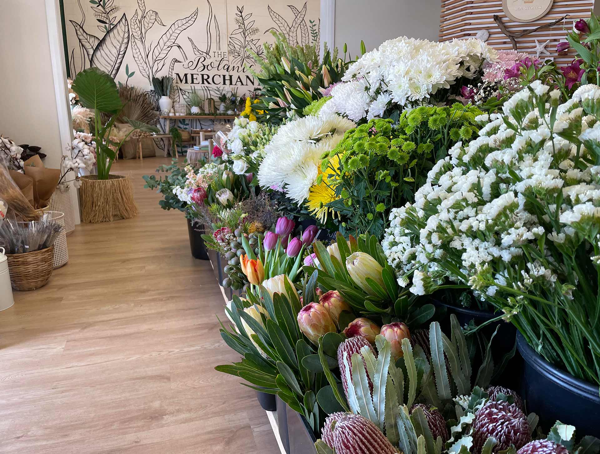 A bunch of flowers are sitting on a table in a room.