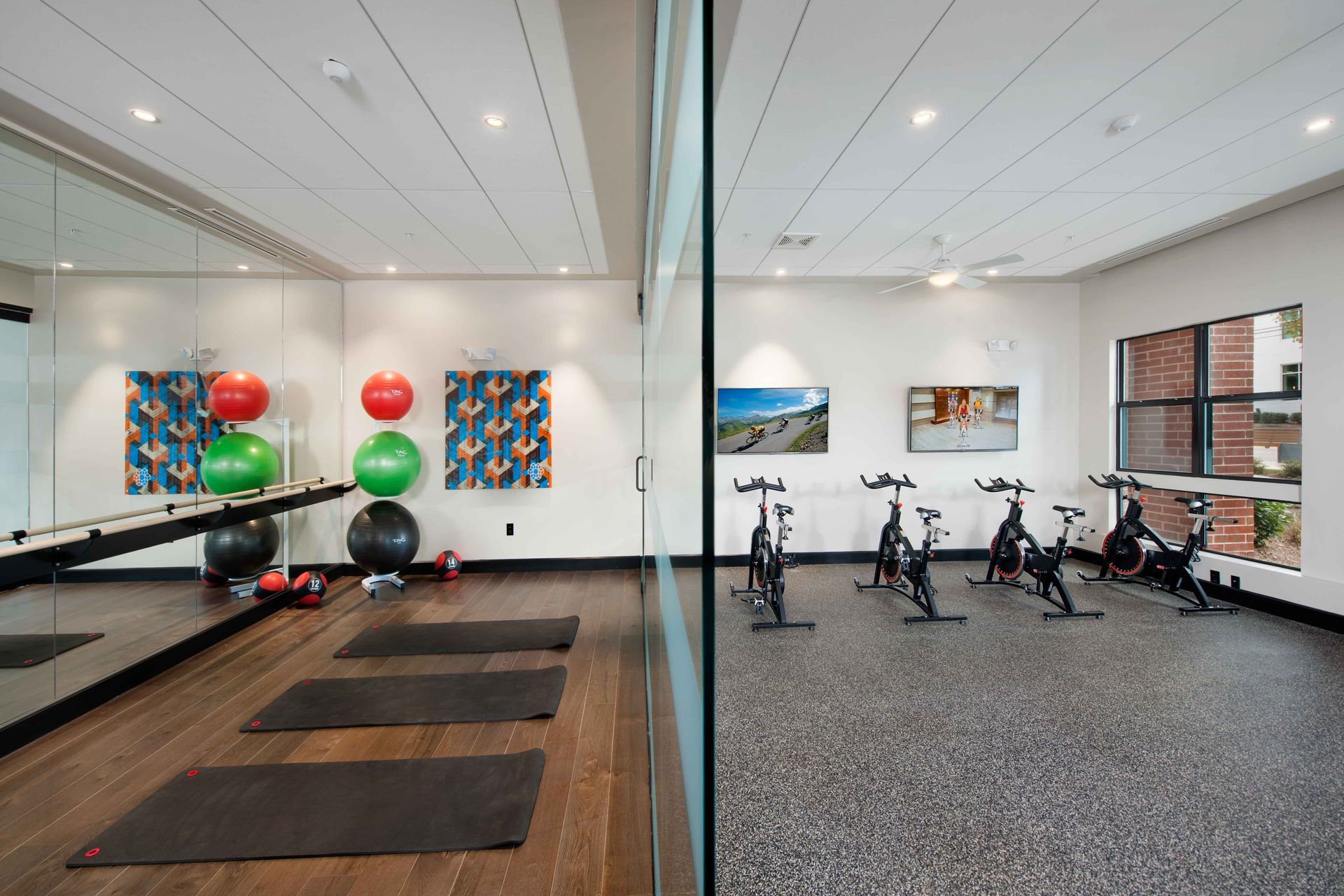 A gym with a lot of exercise bikes and yoga mats.