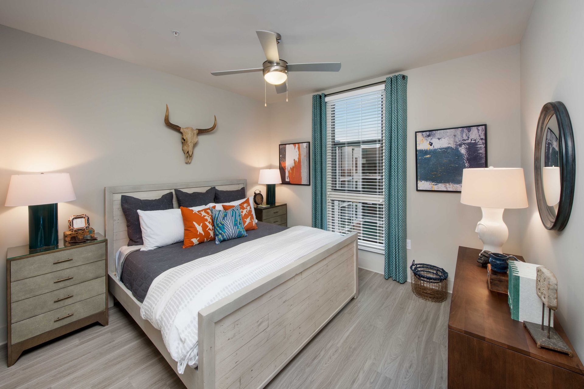 A bedroom with a large bed and a ceiling fan.