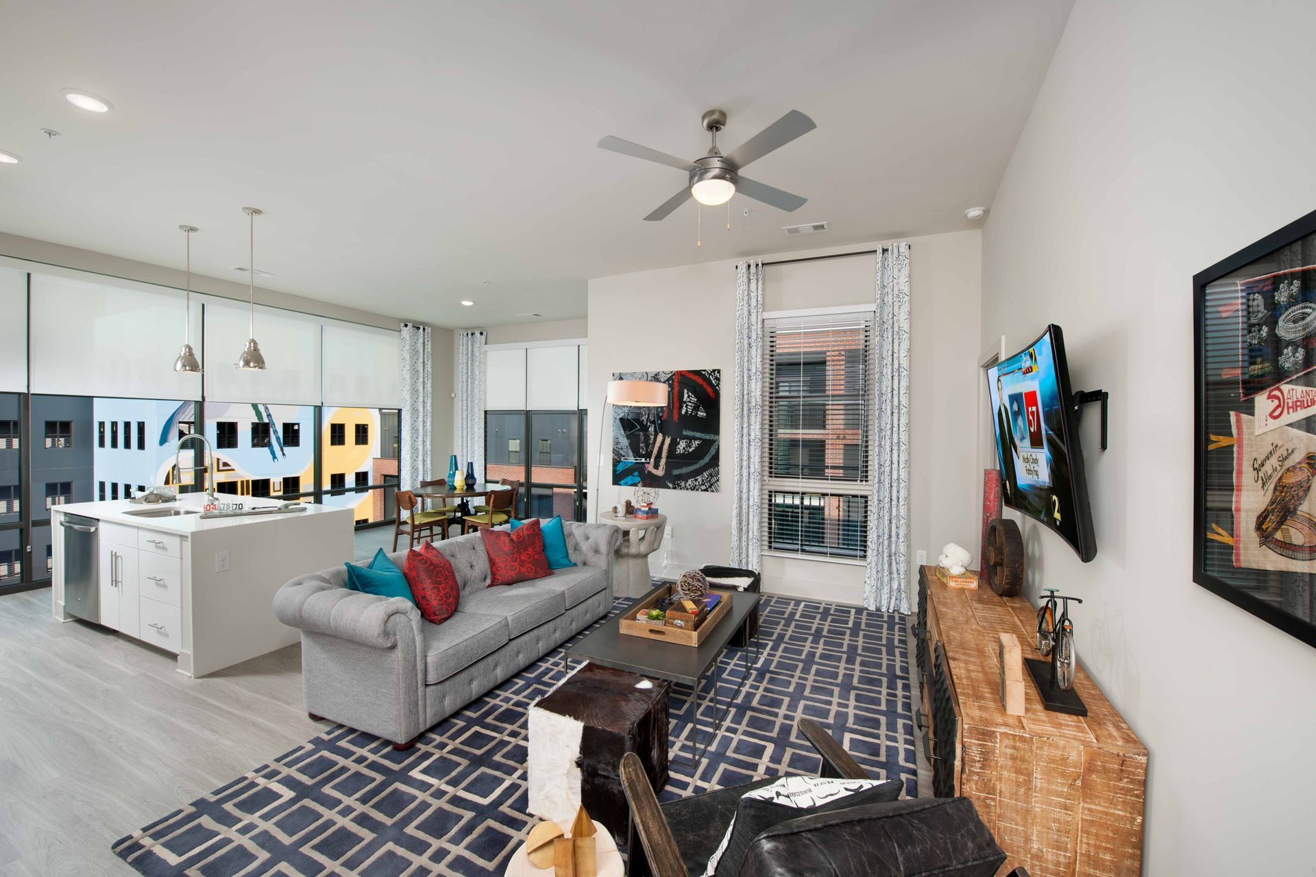 A living room with a couch, television, and ceiling fan.