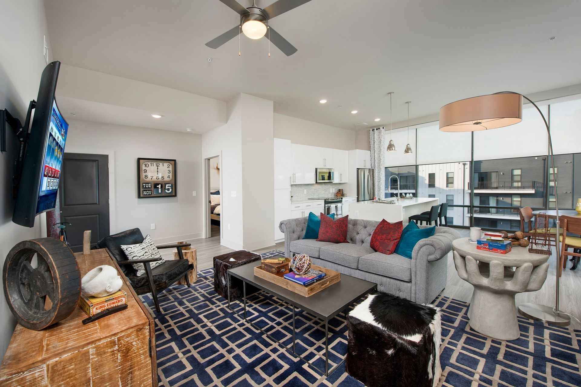 A living room with a couch, table, chairs, and a television.