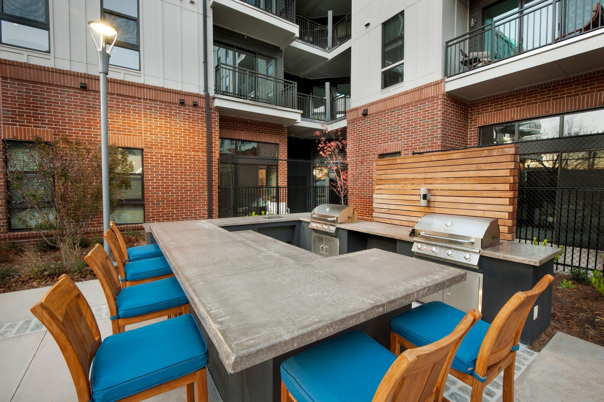 A large table with chairs and a grill in front of a building.