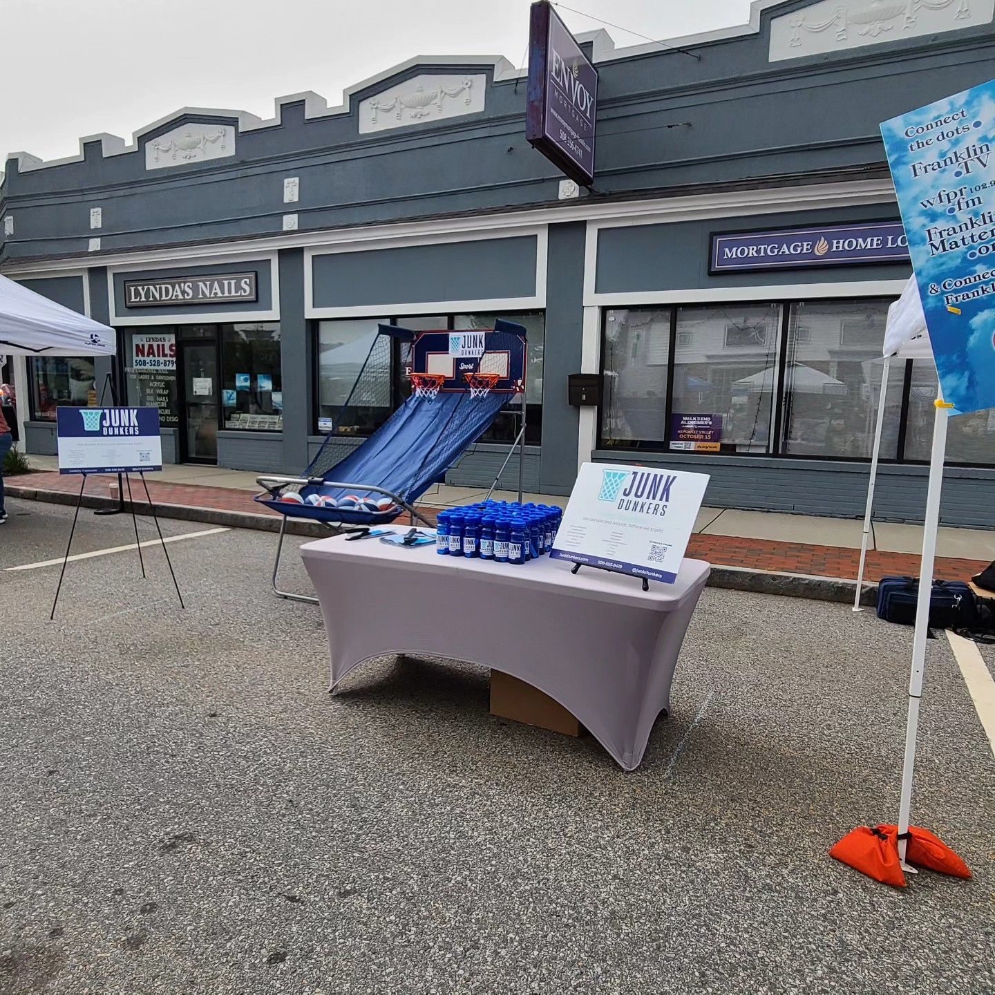A table with a white table cloth is in front of a building.