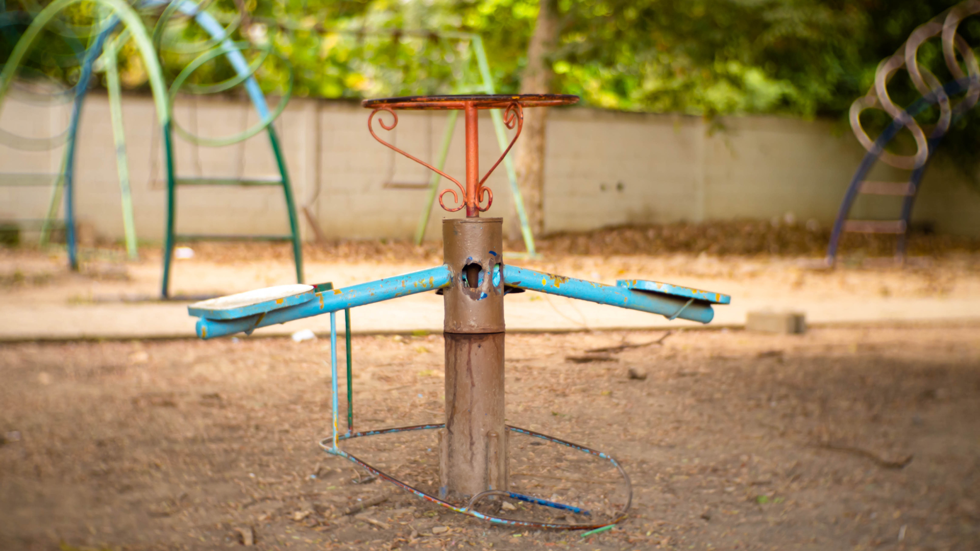 A merry go round is sitting in the middle of a playground.