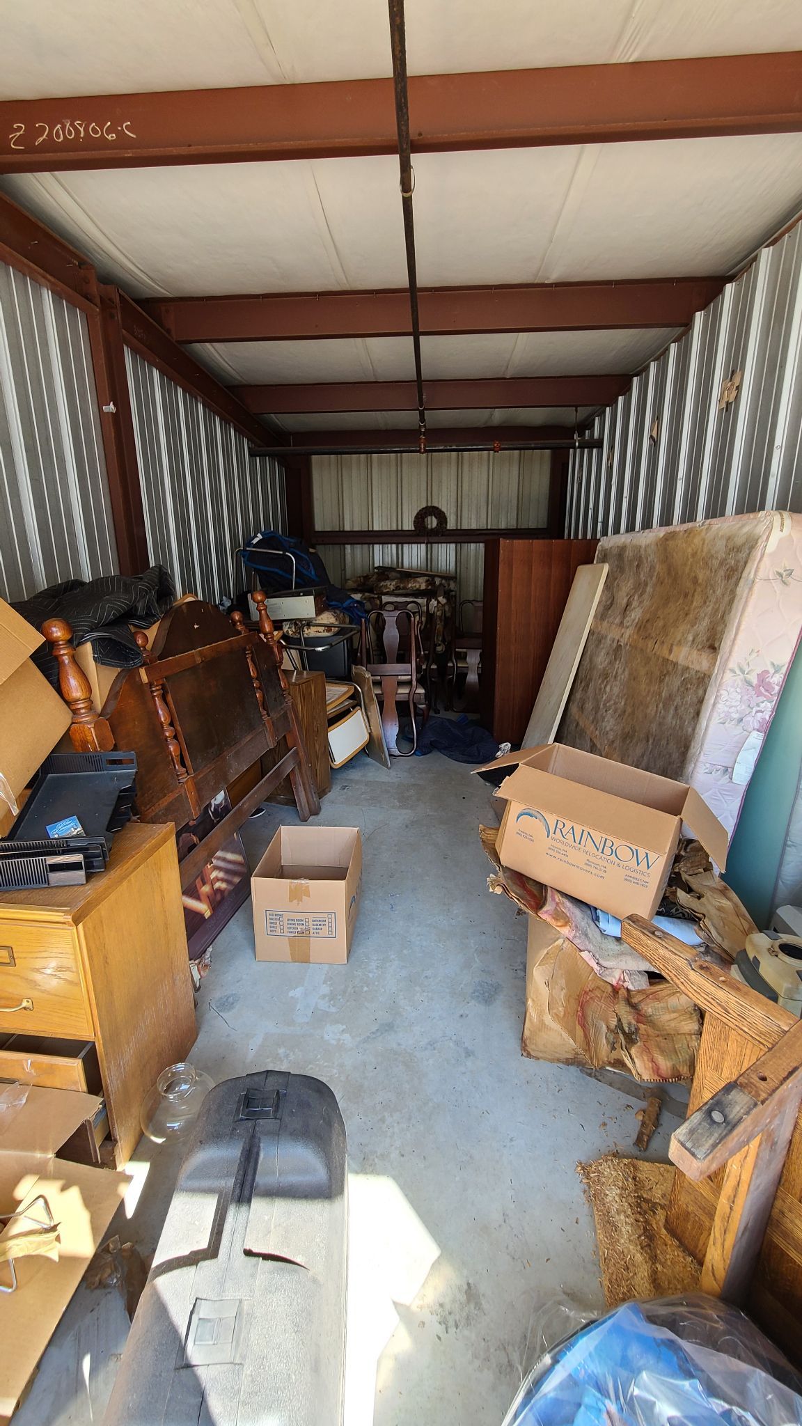 A storage shed filled with lots of furniture and boxes.