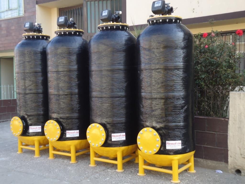 Una fila de tanques negros están alineados frente a un edificio