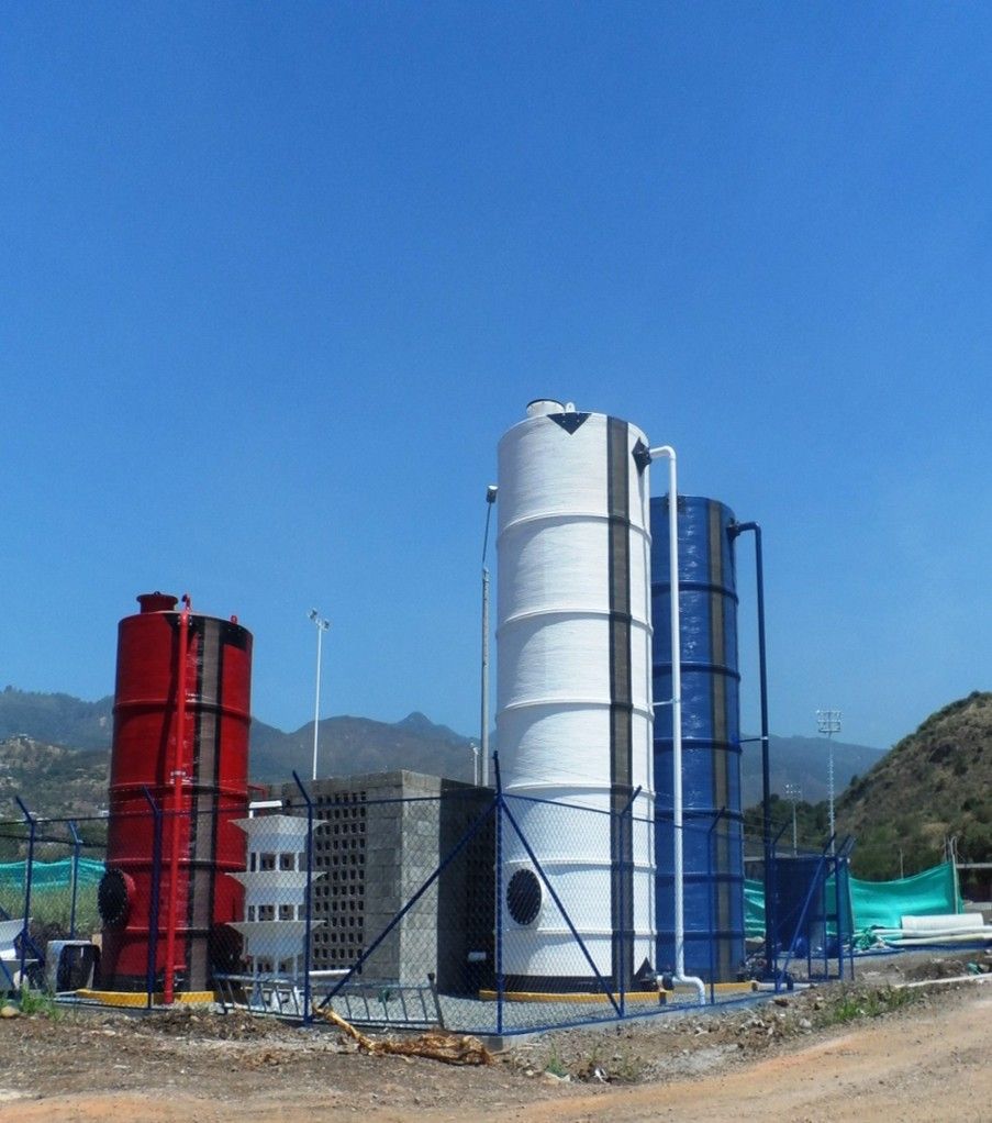 Una fila de silos están alineados en un campo con montañas al fondo