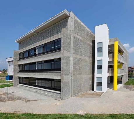 Un gran edificio de hormigón con un poste amarillo en el medio.