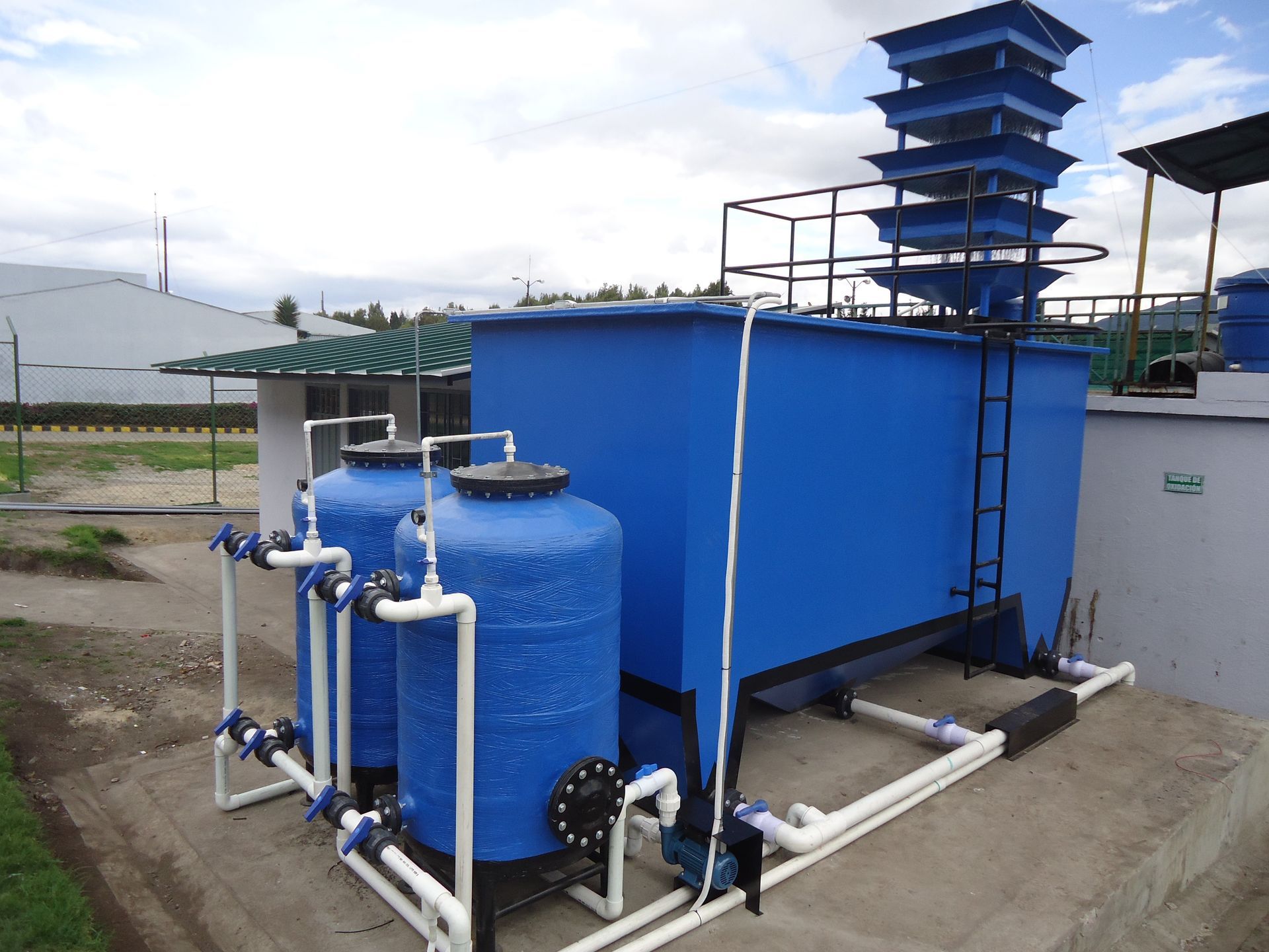 Una fila de tanques azules con tuberías blancas conectadas a ellos.