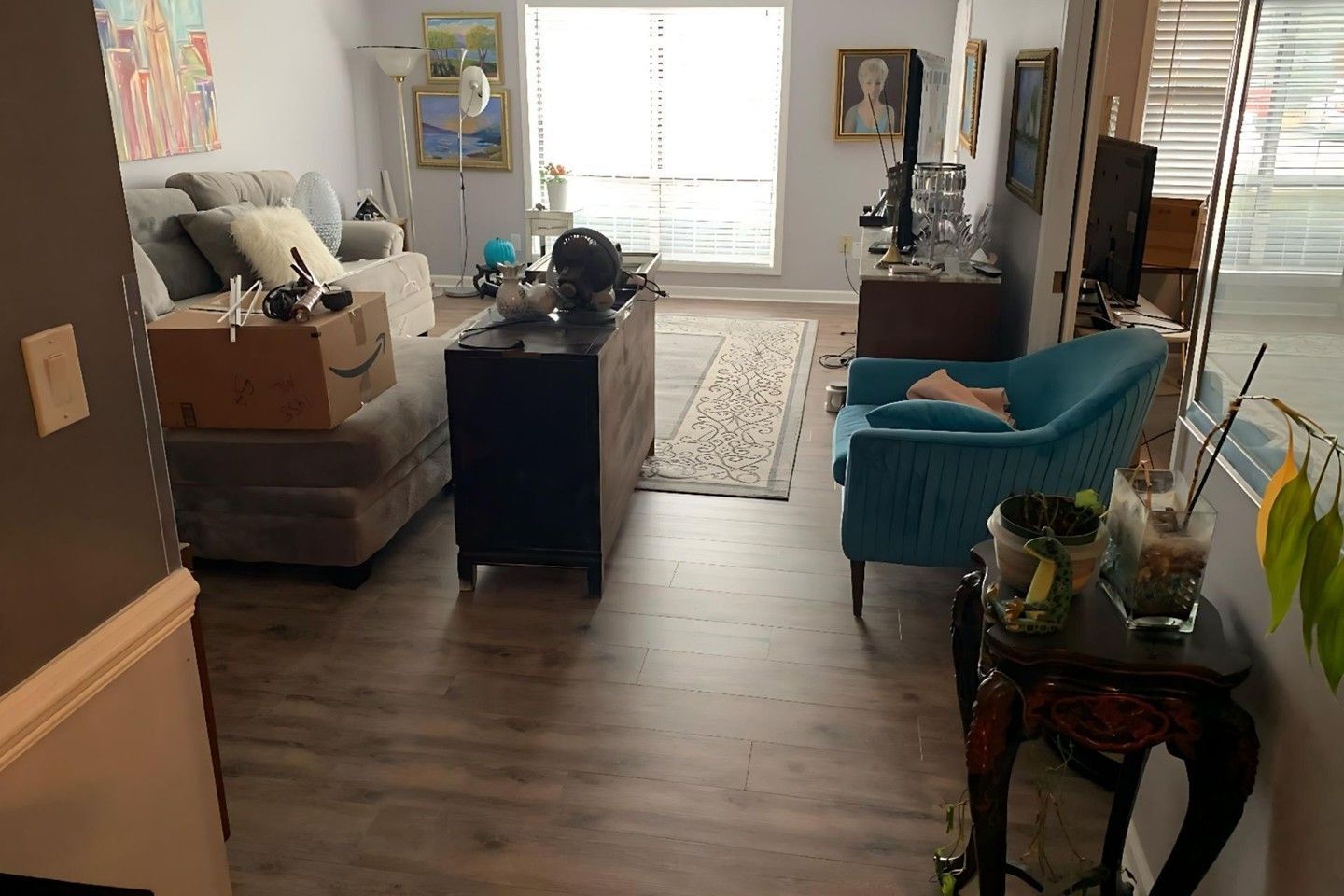 A living room with a couch , chair , table and television.