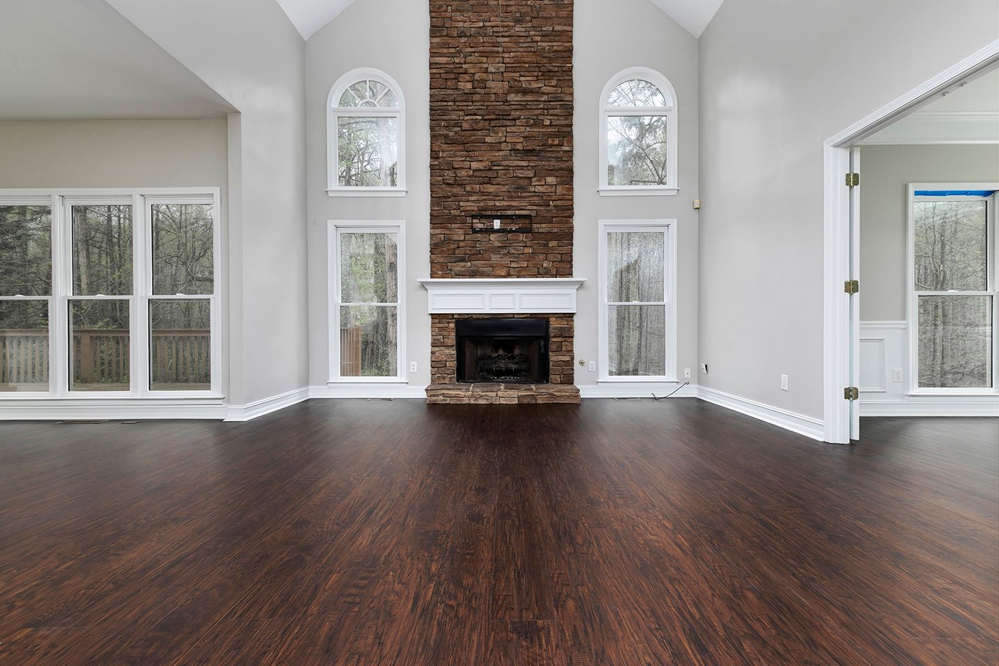 An empty living room with hardwood floors and a fireplace.