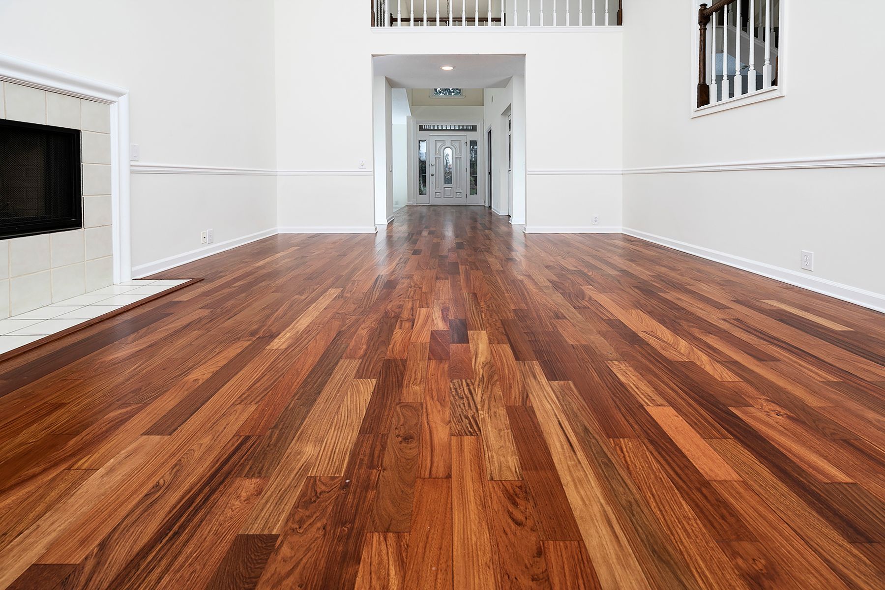 An empty living room with hardwood floors and a fireplace.