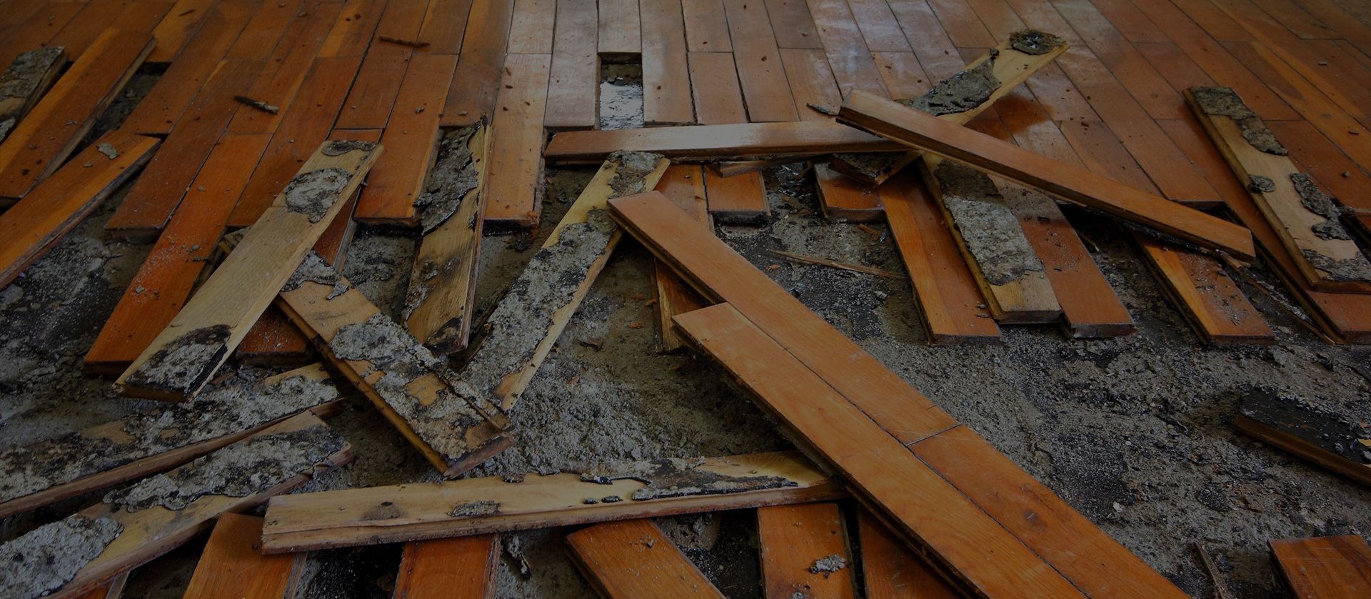 A pile of broken wooden boards on a wooden floor.
