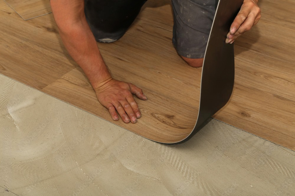 Skilled worker seamlessly joins vinyl floor covering during a home renovation project.