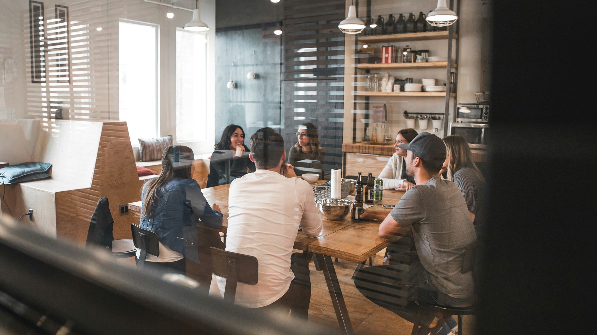 A group of people are sitting around a table in a room.