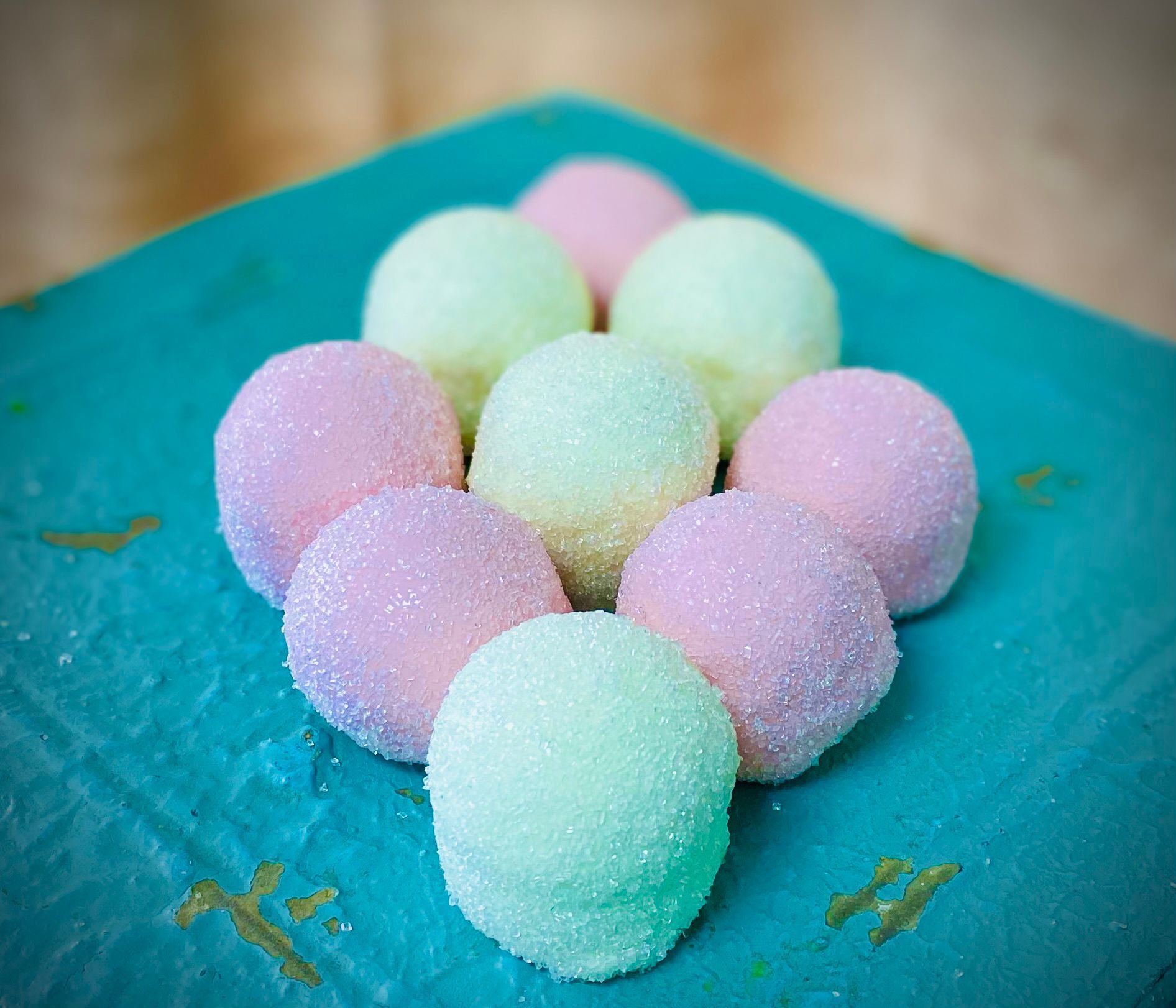 A bunch of candy balls are sitting on top of a blue plate.