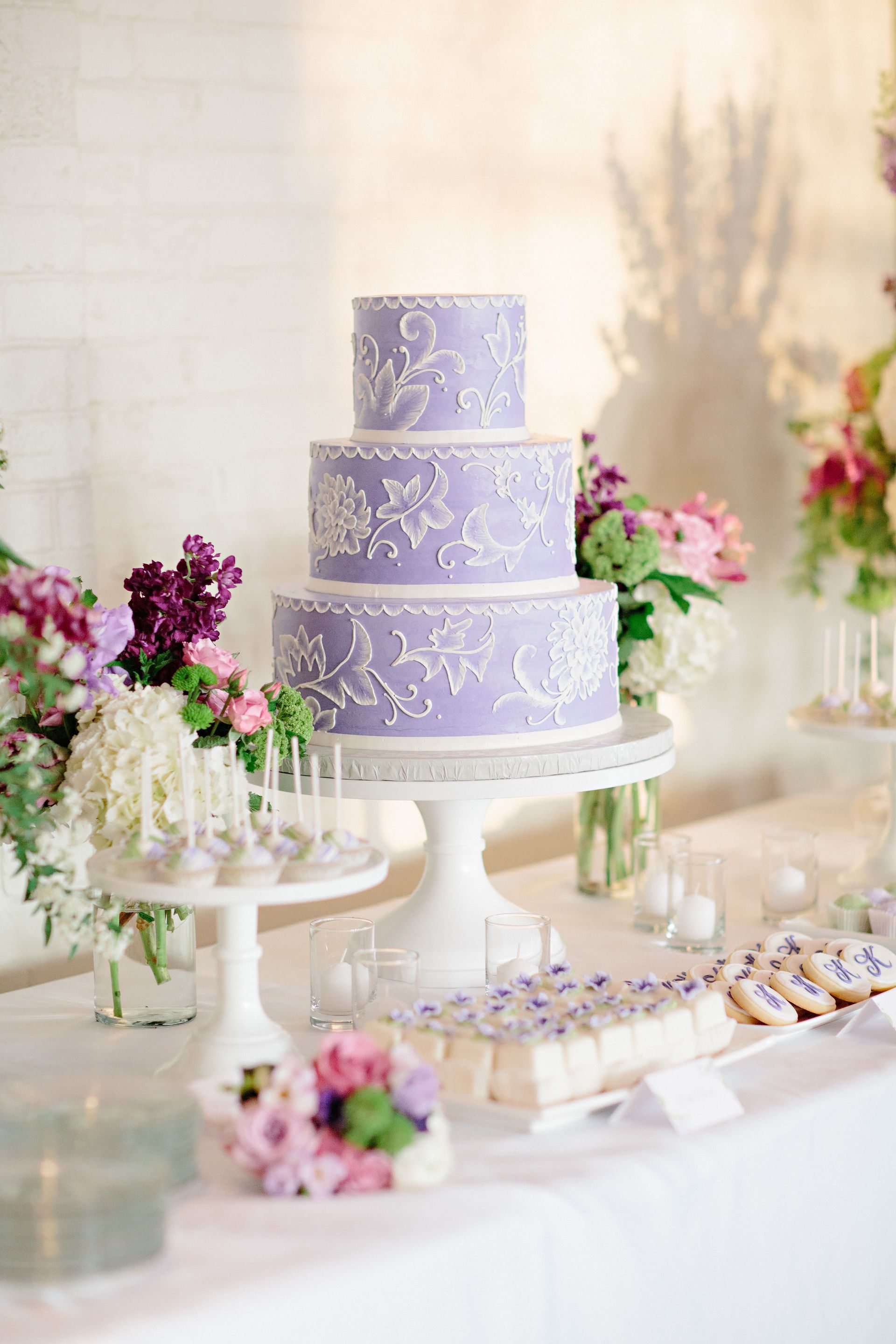 A purple wedding cake is sitting on top of a white table.