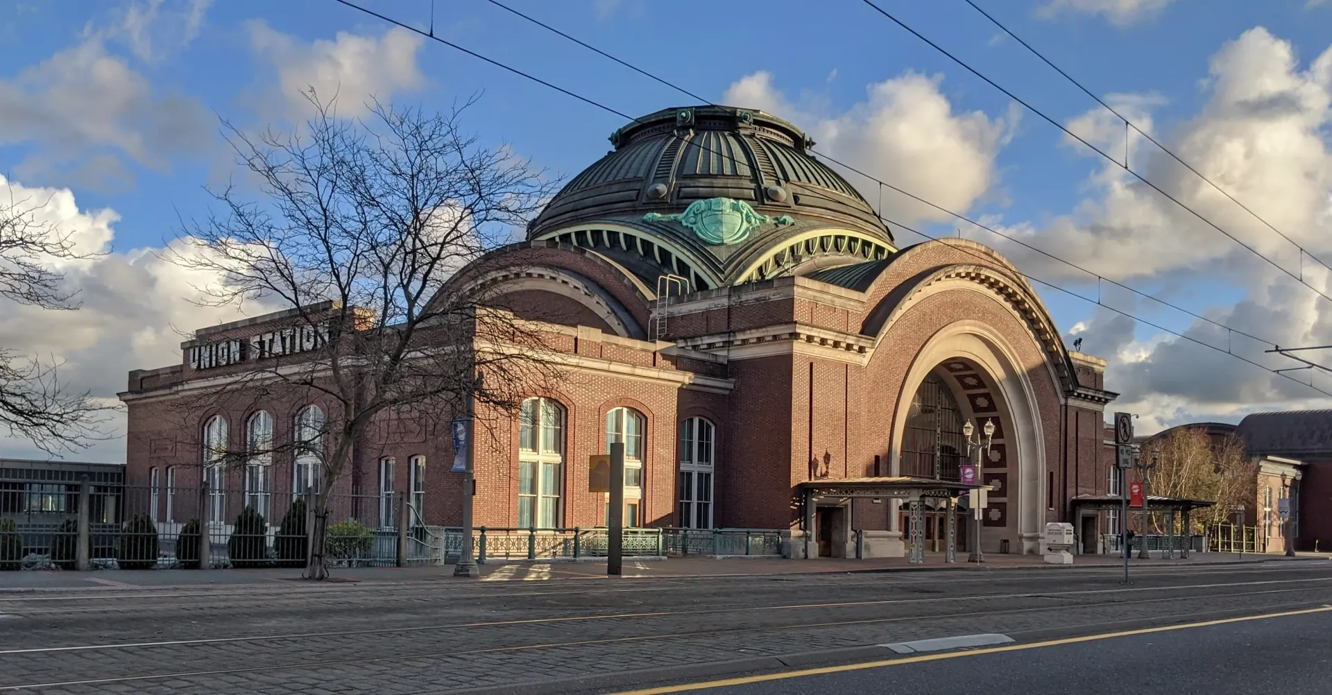 Brick building with copper dome, arched windows, and a blue sky at The Lex in Tacoma, WA.