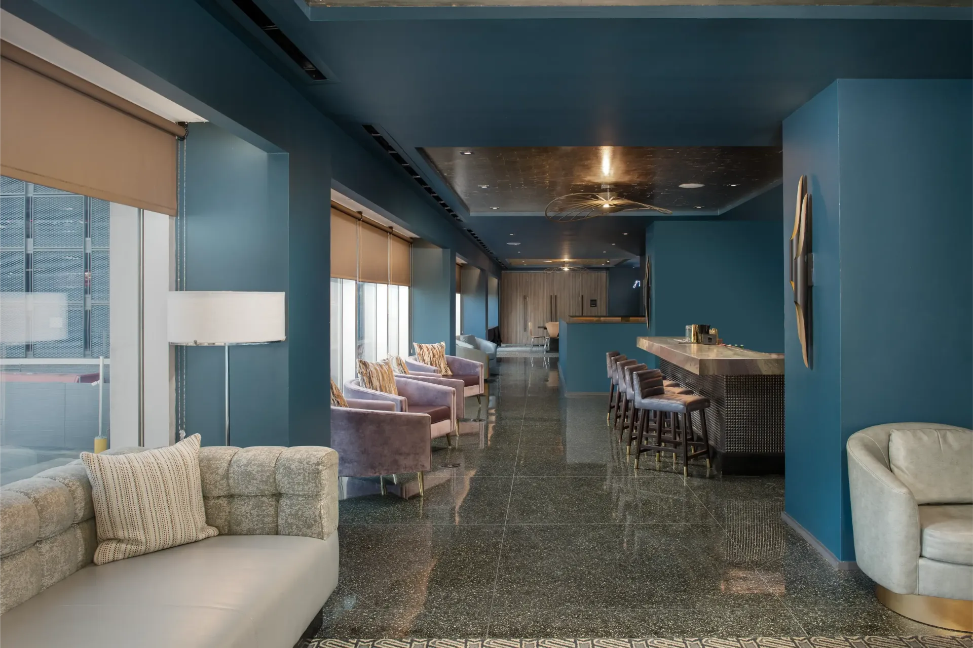 A living room with a couch , chairs , and a bar.