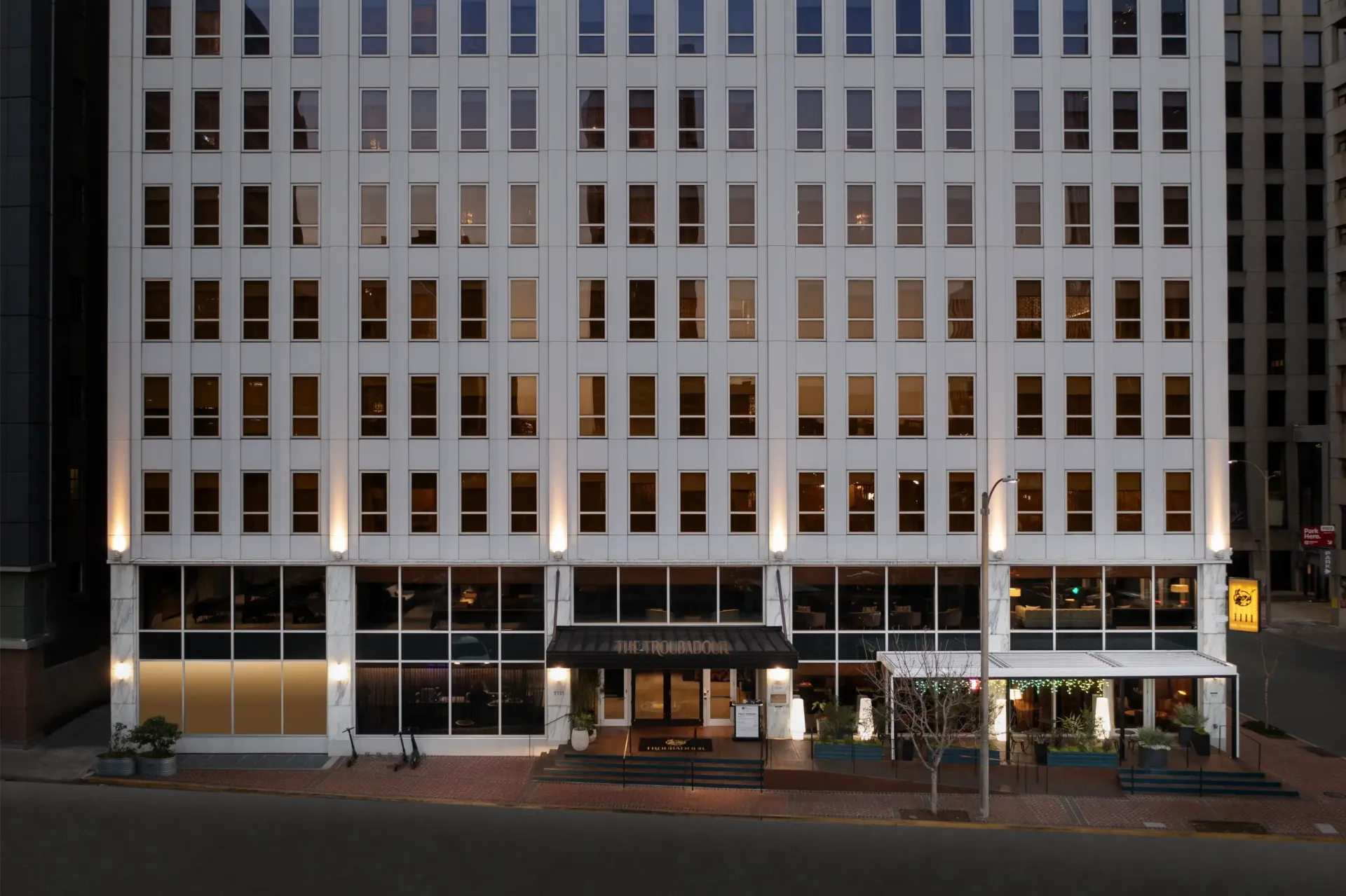 A large white building with lots of windows is lit up at night