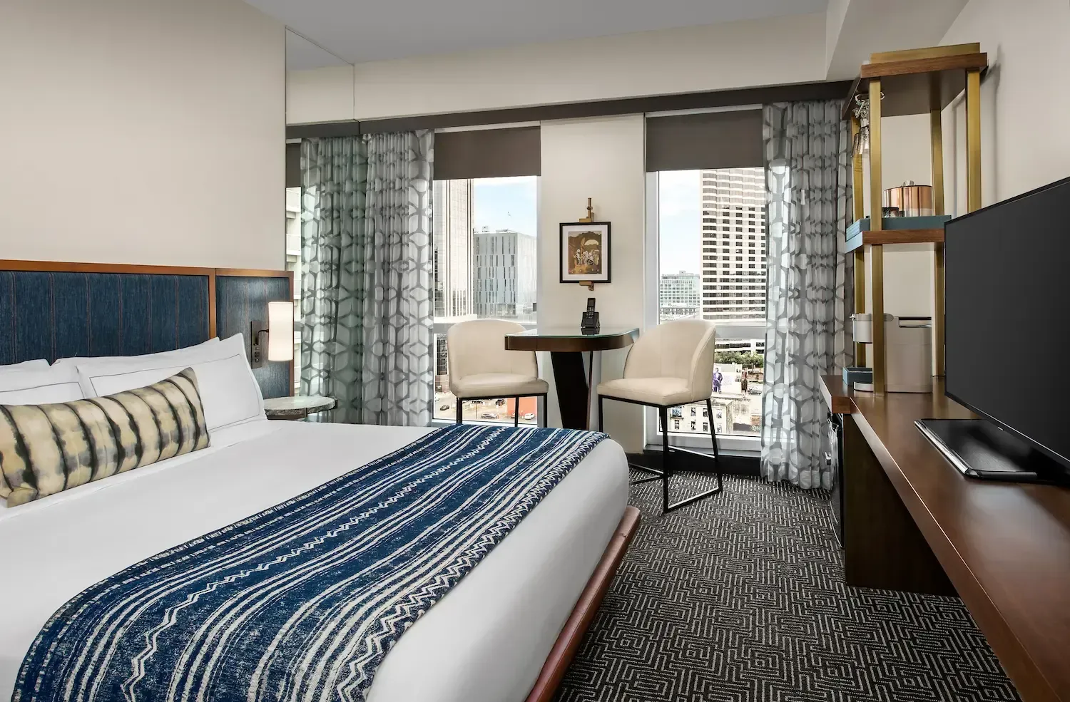 A hotel room with a king size bed and a flat screen tv