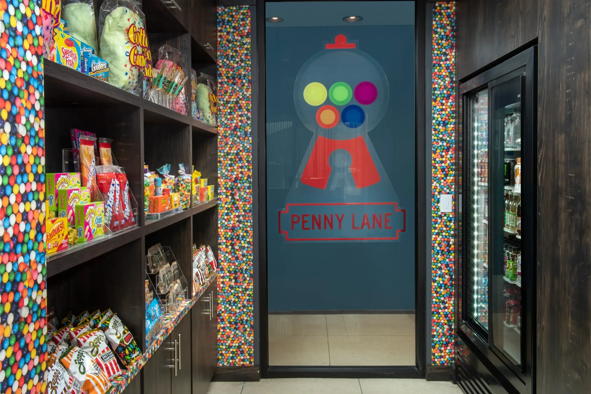 A penny lane candy store with a gumball machine on the wall.