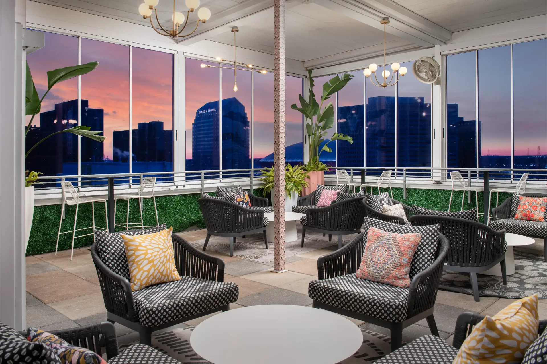 There are many chairs and tables in the room with a view of the city.