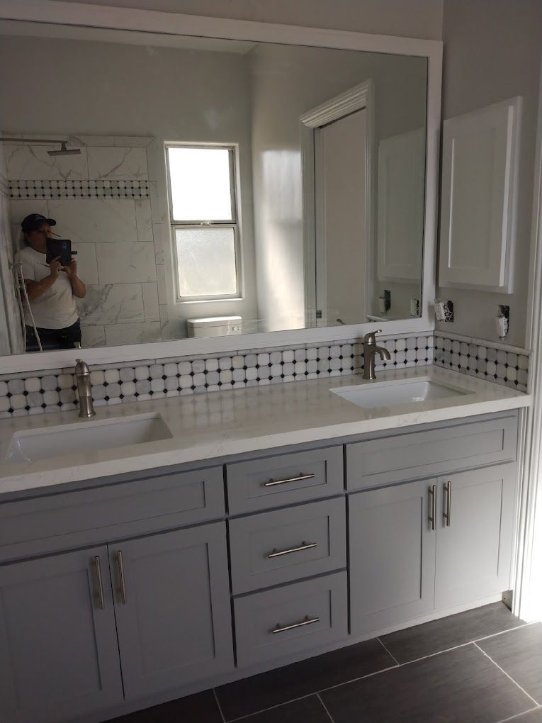 A bathroom with two sinks and a large mirror