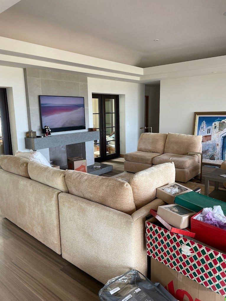 A living room with a couch , chairs , a television and a fireplace.