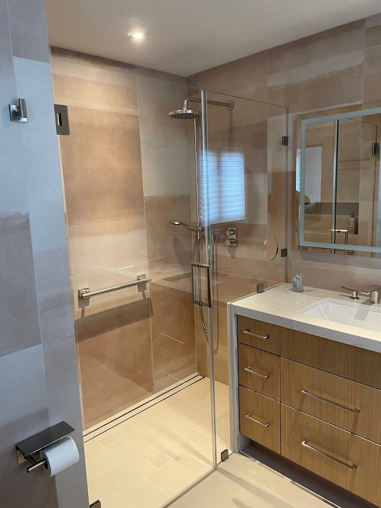 A bathroom with a walk in shower , sink and mirror.