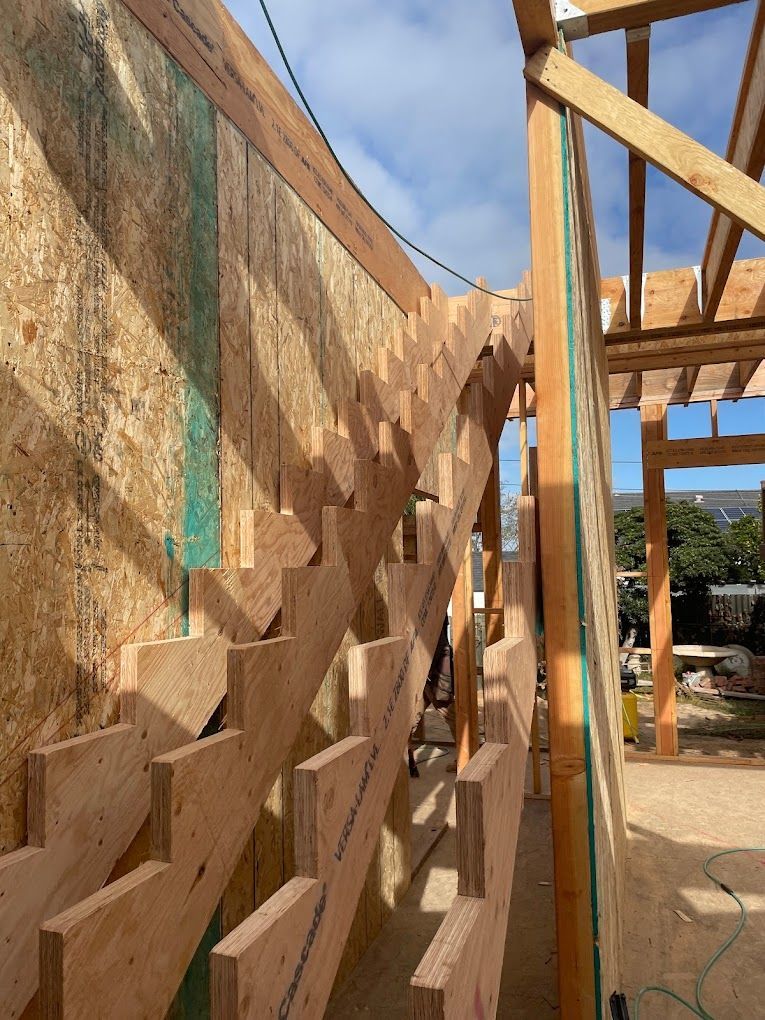 A wooden staircase is being built in a building under construction.