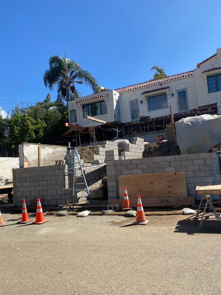 A large white house is being built on a hill