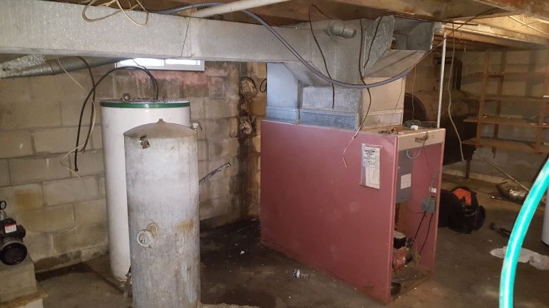 Basement with furnace and water heater. Concrete block walls and ductwork are visible.