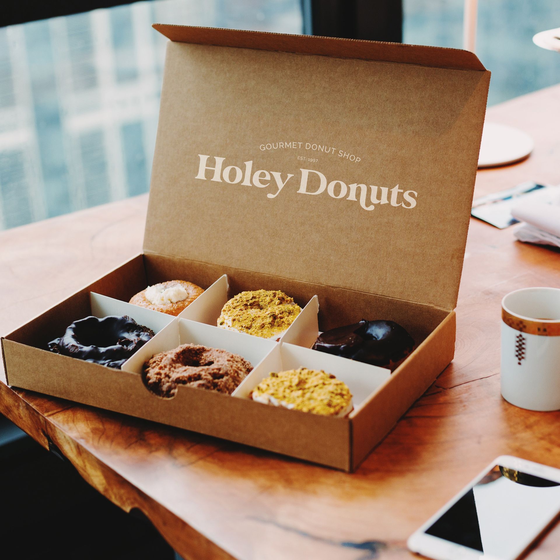 A box of holey donuts sits on a table
