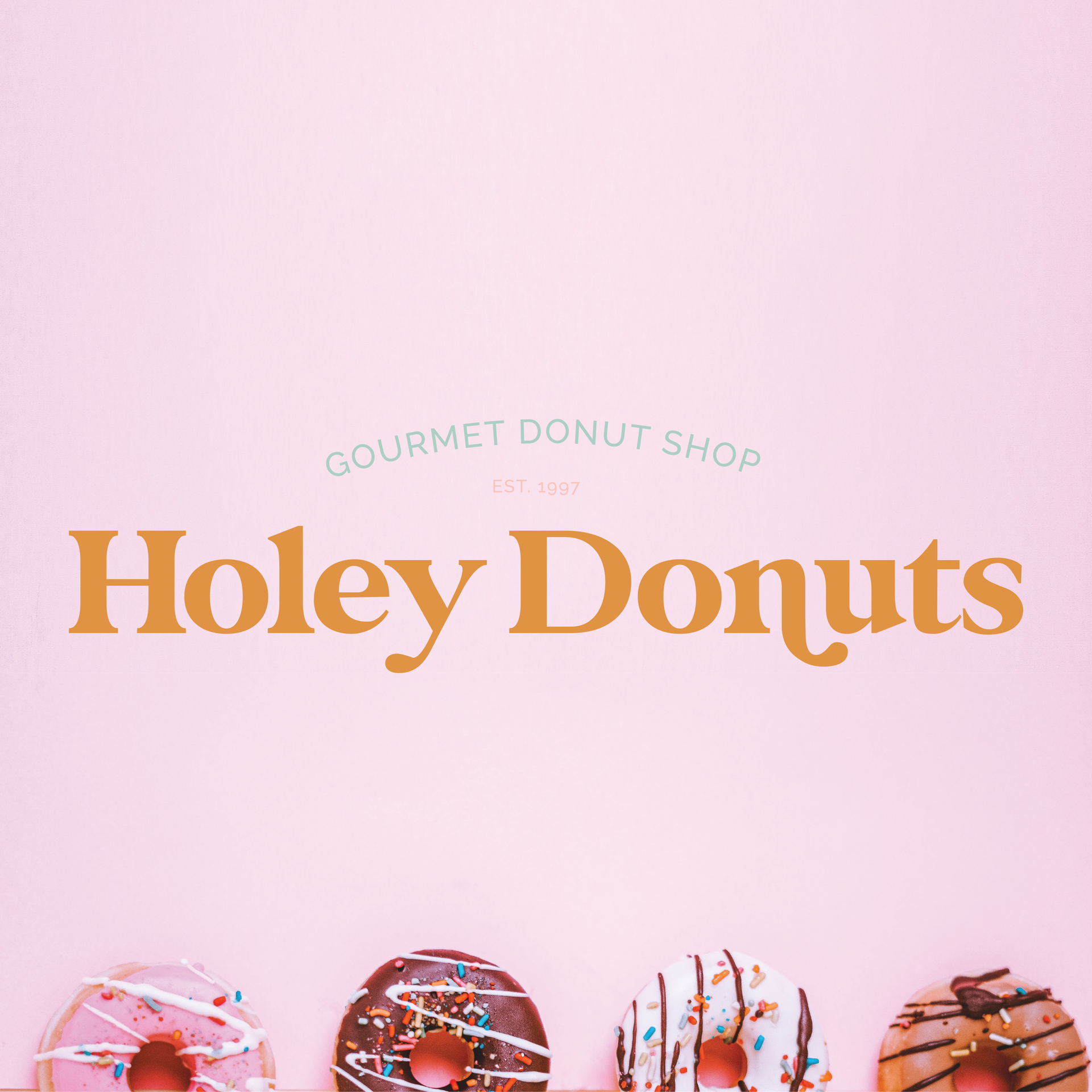 Three donuts are lined up in a row on a pink background.