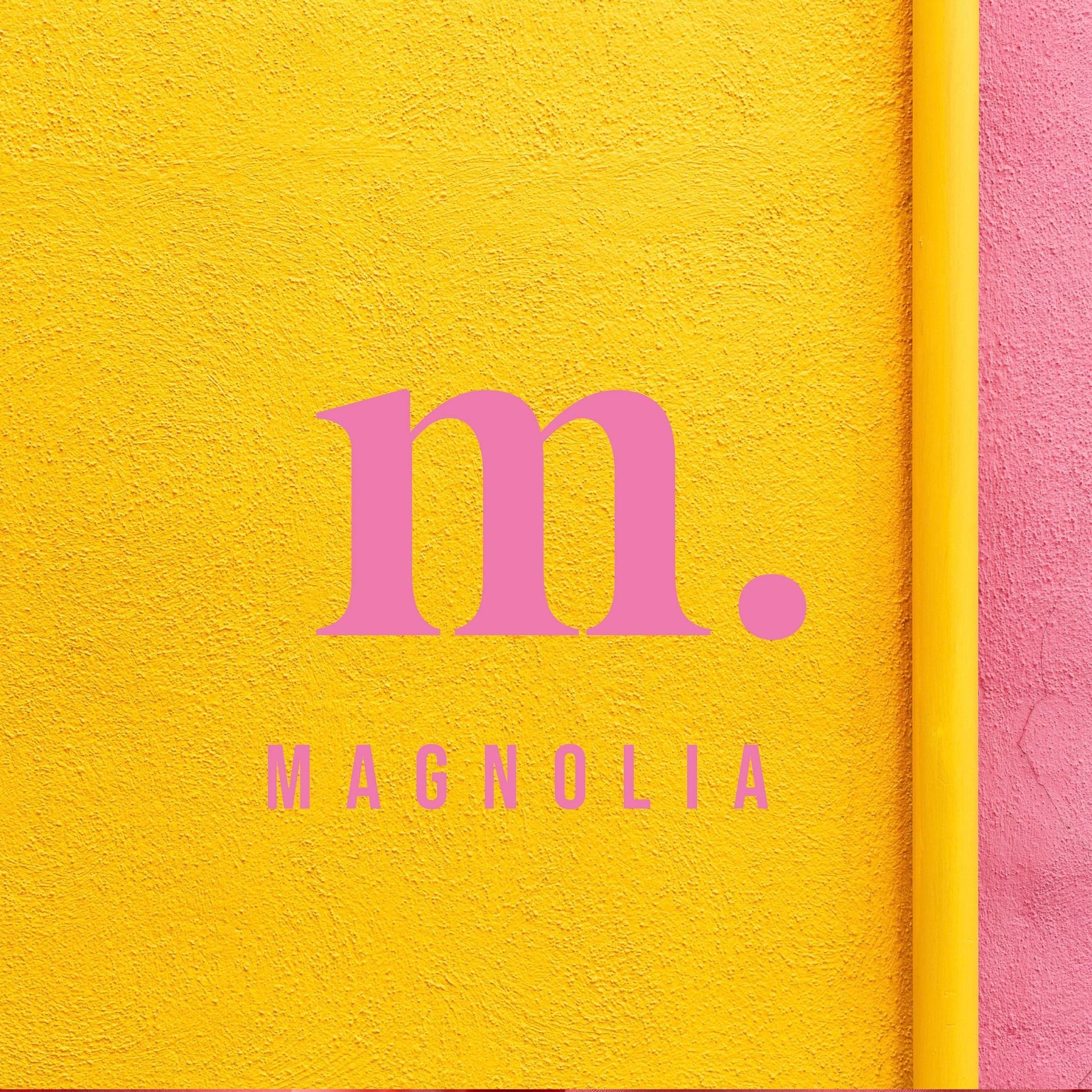 A yellow wall with a pink magnolia logo on it.