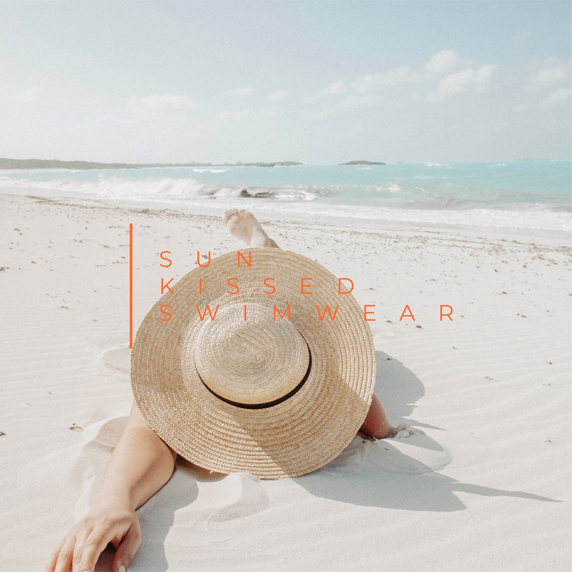 A woman wearing a straw hat is laying on the beach